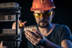 male-electrician-works-switchboard-with-electrical-connecting-cable